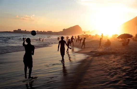 Personnes s'amusant sur une plage au coucher du soleil à Rio de Janeiro