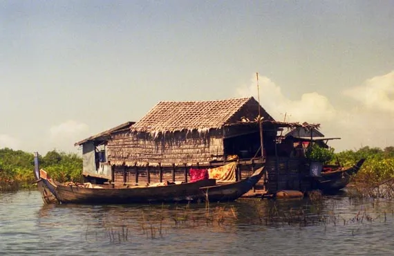 Maison en mais et bateau sur un lac au Cambodge