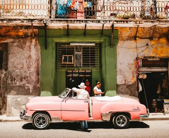 Voiture rose devant une maison dans une rue de la Havane à Cuba