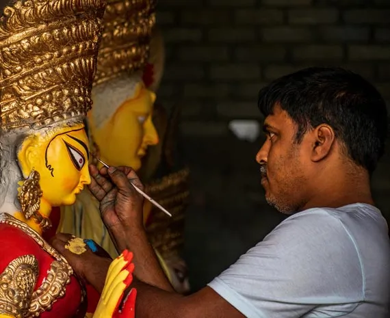 Homme peignant une statue en Inde du Nord