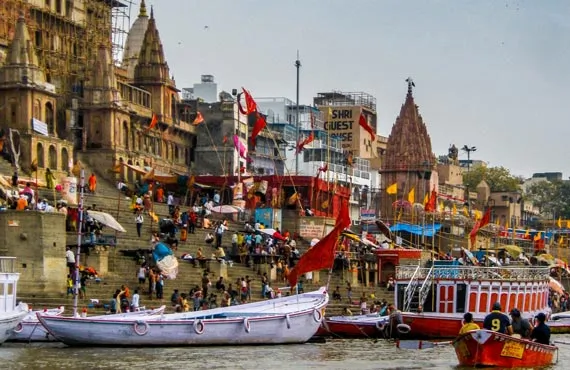 Batiments typiques au bord du fleuve et bateaux colorés à Varanasi en Inde du Nord